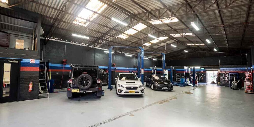 Late model cars in clean mechanic workshop.